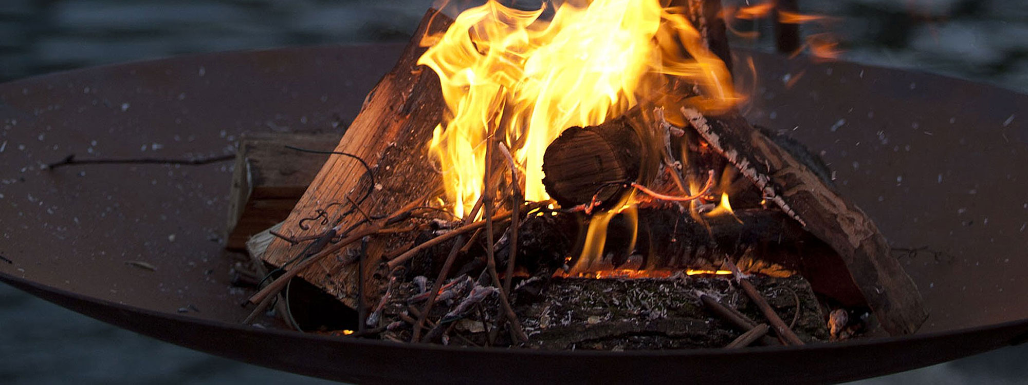 Image of detail of AK47 Tripee fire bowl with sizzling embers and flames within