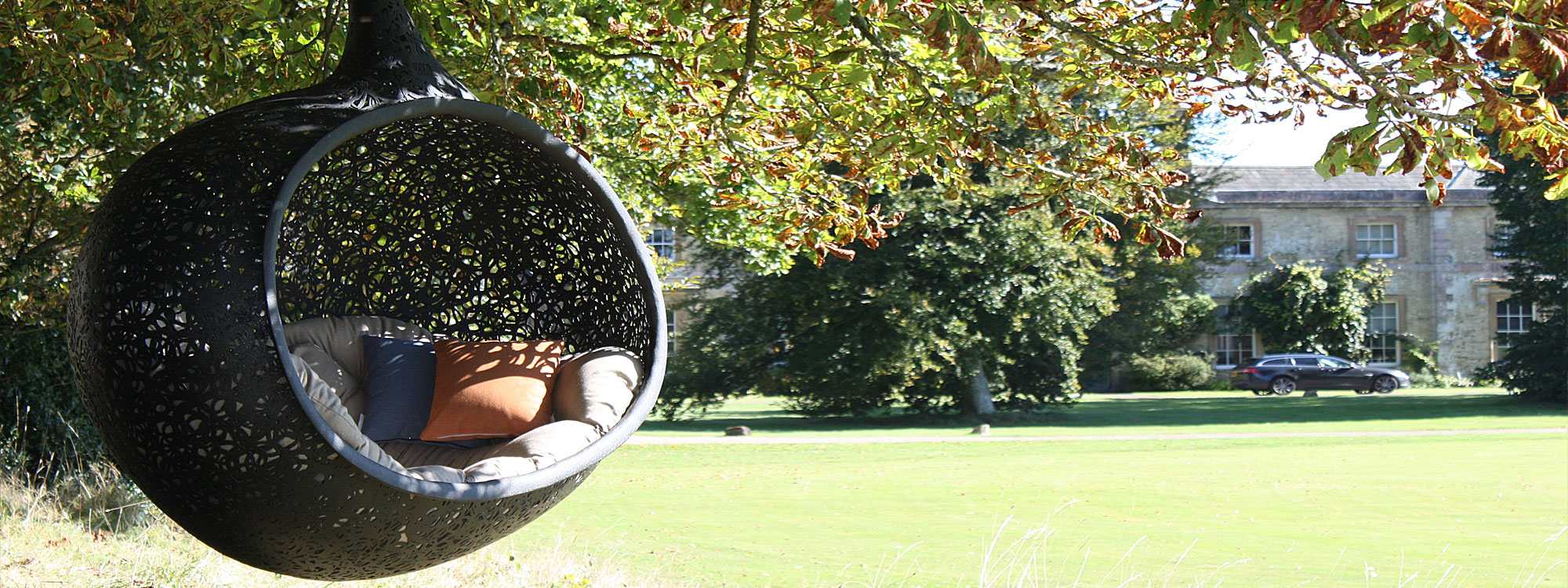 Image of Bios Hide sofa swing seat outside Sussex stately home.
