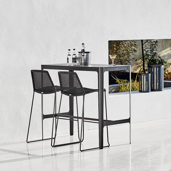 Image of black Cane-line Breeze bar chairs and black aluminium Cut high bar table on white-washed terrace