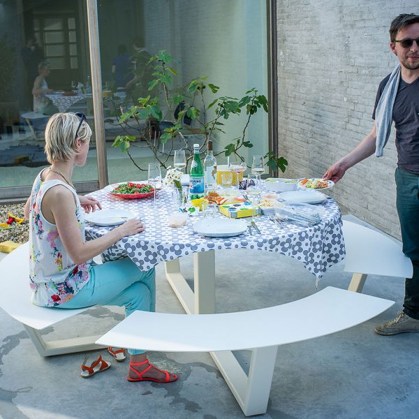 Image of Cassecroute La Grande Ronde contemporary picnic table in white, shown with table set for dinner as guests arrive and take their seats