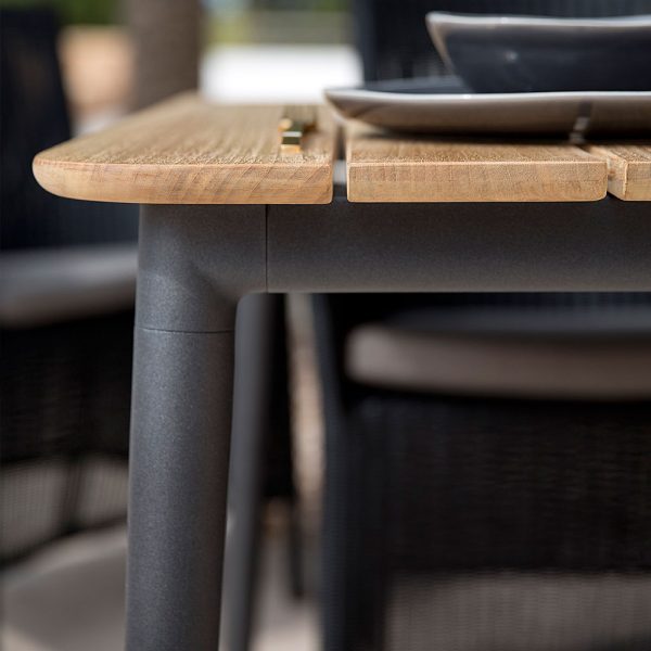 Image of detail of Core dining table's lava-grey aluminum legs and teak table top by Caneline