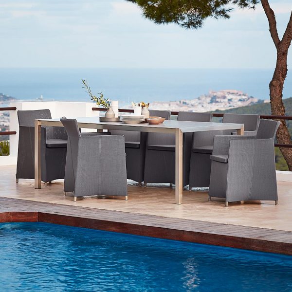 Image of Diamond outdoor armchairs around Cane-line stainless steel dining table on poolside