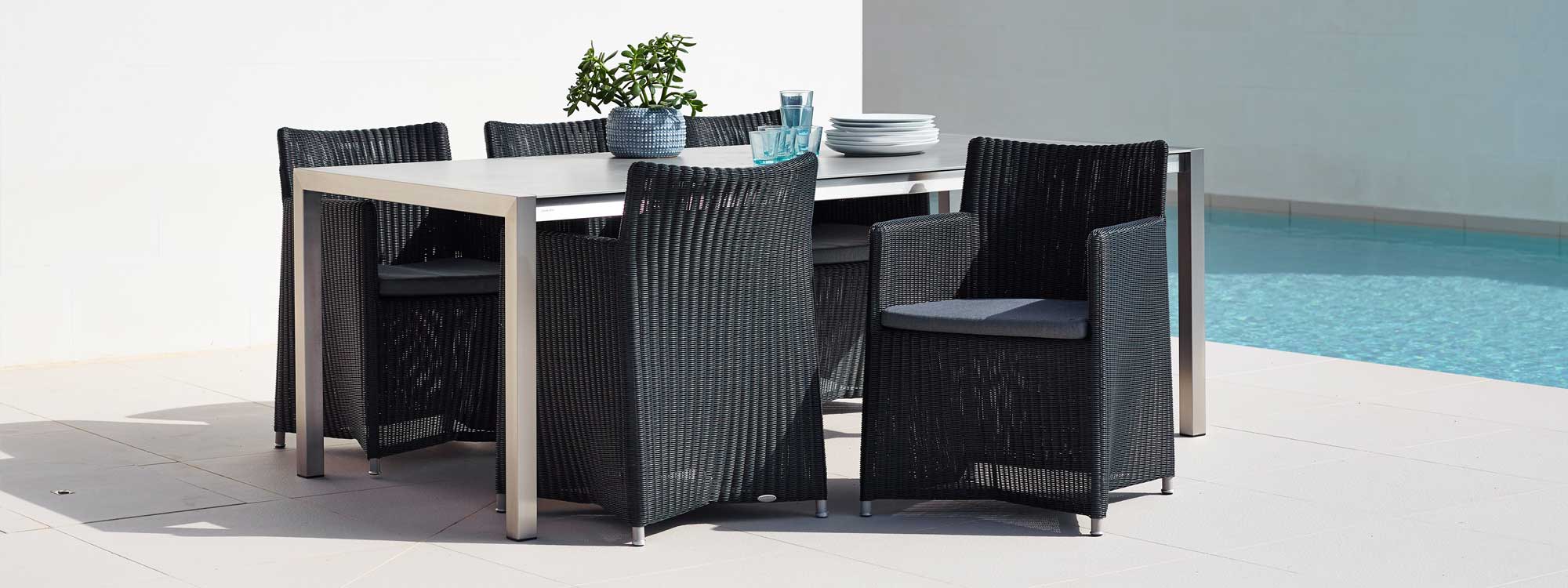 Image of Diamond garden chairs in black rattan together with Cane-line stainless steel garden table