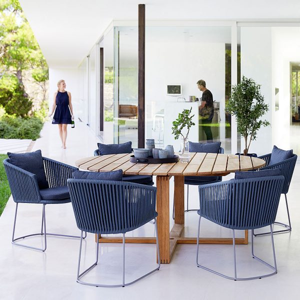 Image of Endless round teak dining table and Moments dining chairs in blue soft rope by Cane-line