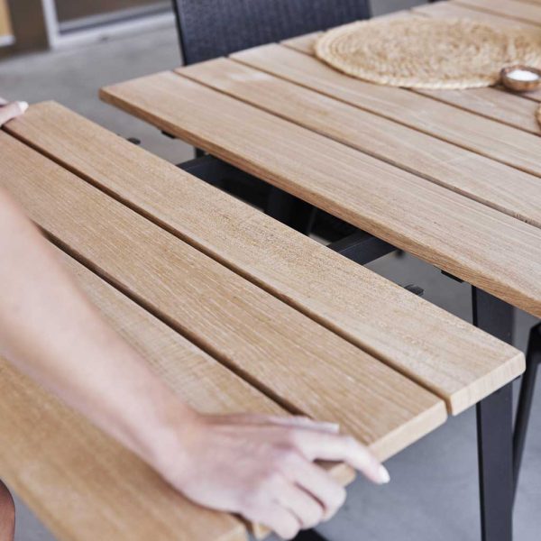 Image of man fitting teak extension leaf to Copenhagen garden table by Cane-line