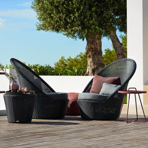Image of pair of graphite coloured Kingston outdoor lounge chairs and foot stool by Caneline on a wooden decked outdoor terrace