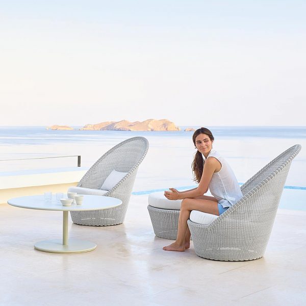 Image of woman sat in white-grey Kingston garden easy chair shown next to white Go coffee table, by Caneline