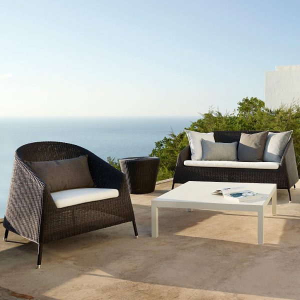 Image of Cane-line Kingston mocca cane furniture on terrace with hazy sea in background