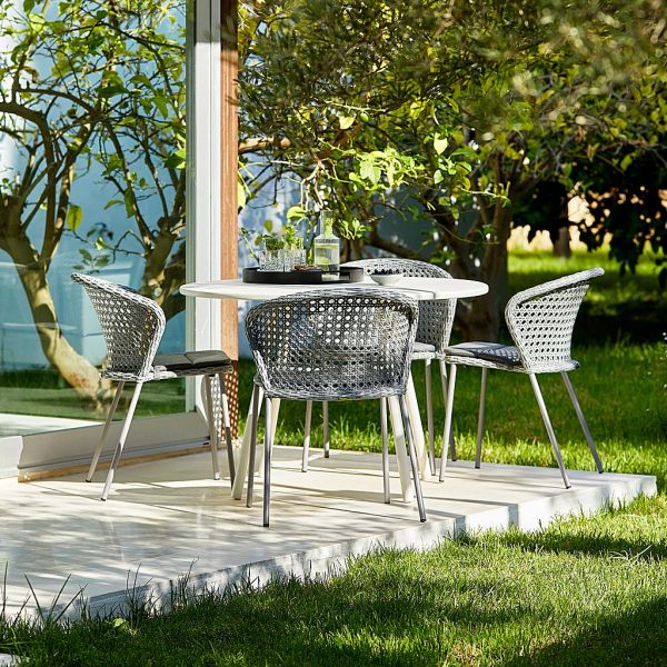 Image of grey Lean garden chairs and white Area garden table by Cane-line