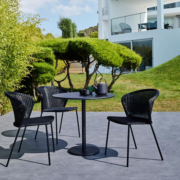 Image of black Cane-line Lean rattan garden chairs and black Go bistro table on sunny terrace