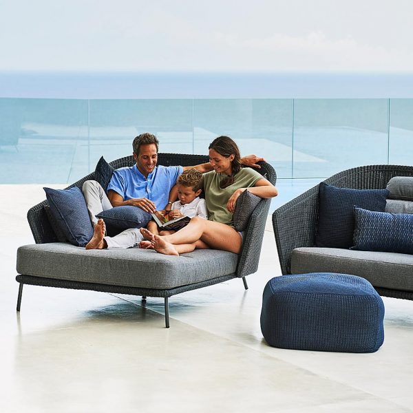 Image of 2 adults and a child lying on dark-grey garden daybed next to Mega dark grey lounge furniture by Caneline