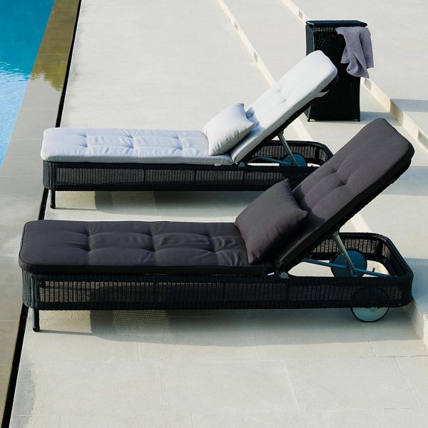 Image of pair of Presley black rattan sun lounger by Cane-line, shown on poolside