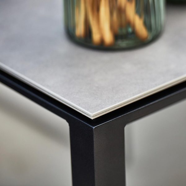 Image of detail of Lava-grey aluminium frame and grey ceramic top of Pure modern garden table by Cane-line