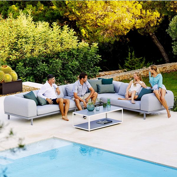 Image across swimming pool of Caneline luxury garden sofa in light grey