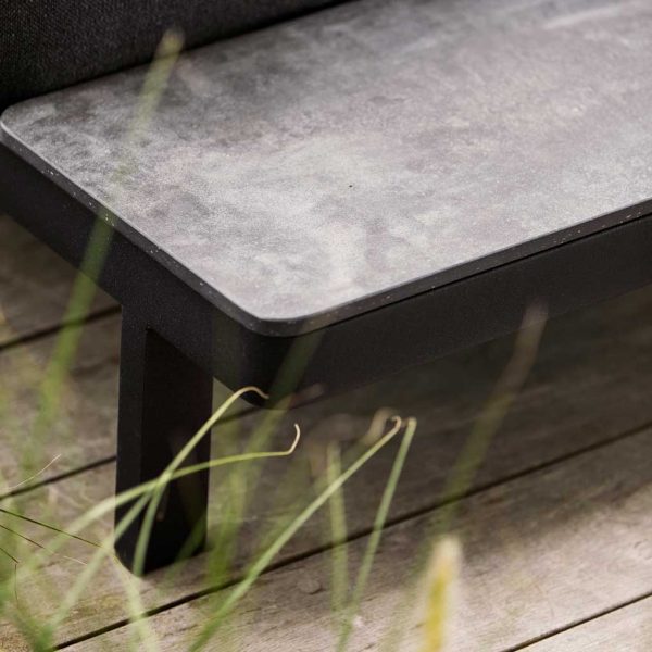 Image of detail of Space sofa's integrated side table in black Fossil ceramic by Cane-line