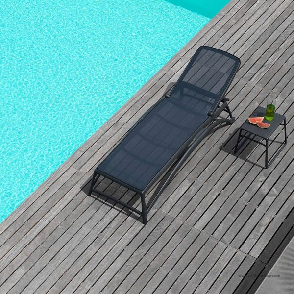 Image of aerial view of Atlantico anthracite coloured hotel sun bed with Pop side table by Nardi, shown on wooden decked poolside