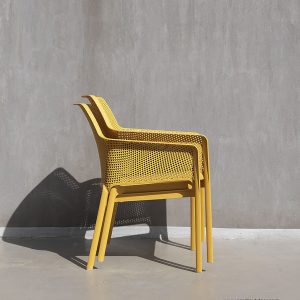 Image of pair of stacked Net garden lounge chairs by Nardi, shown in mustard finish polypropylene
