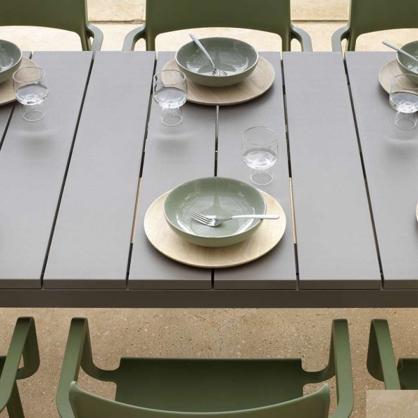 Image showing slatted table top of Rio garden table, with Trill green outdoor armchairs either side
