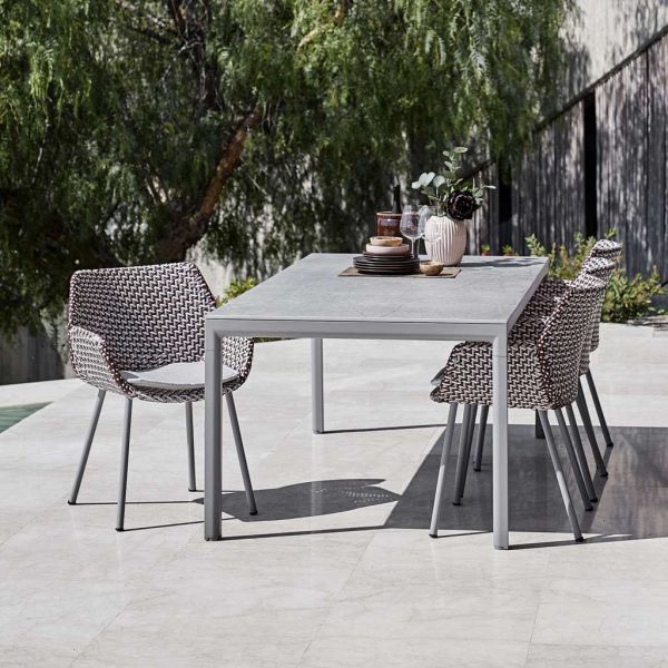 Image of light grey Drop ceramic table with Vibe woven rattan garden chairs by Cane-line