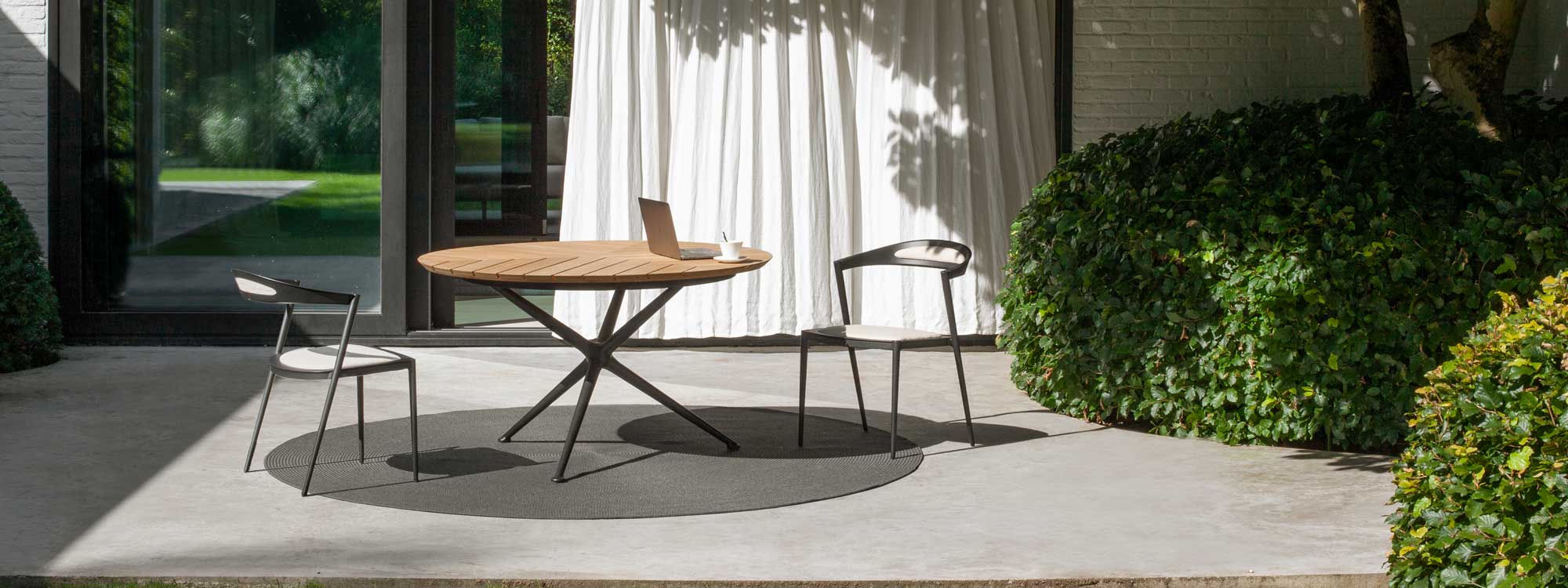 Image of circular Exes table with teak table top and Styletto chair by Royal Botania