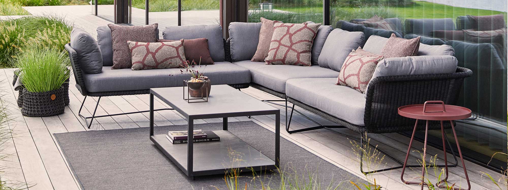 Image of black Horizon rattan corner sofa with grey cushions, together with Level rectangular low table by Cane-line