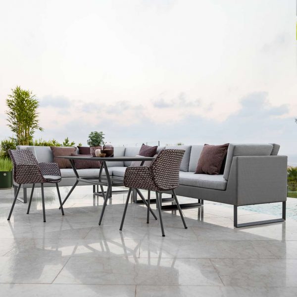 Image of Connect garden dining sofa and Vibe rattan armchairs around Joy rectangular dining table by Cane-line