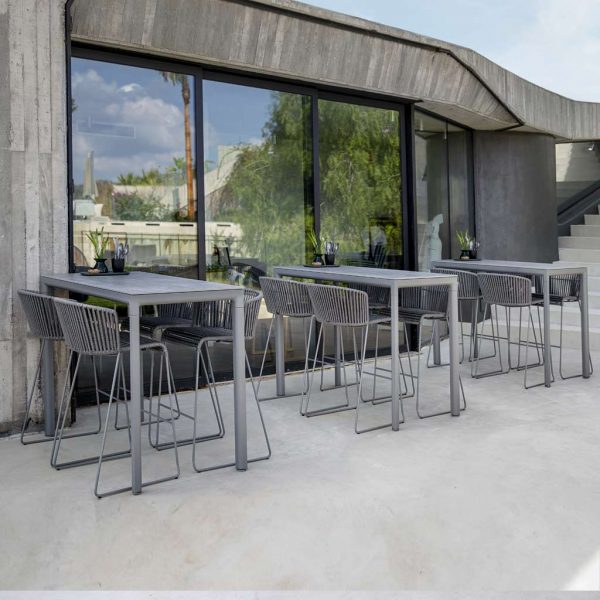 Image of outdoor bar terrace with 3 Drop bar tables and Moments grey bar stools by Cane-line furniture
