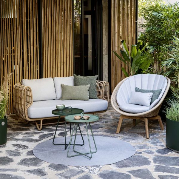 Image of terrace with Caneline Nest cane sofa and Peacock split cane lounge chair