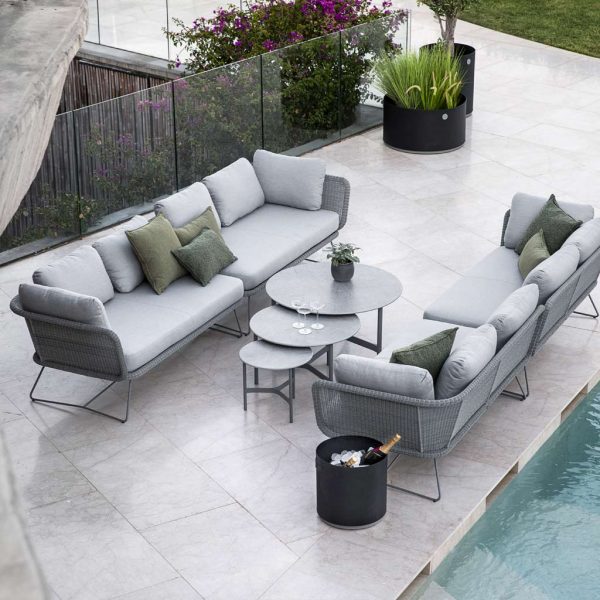 Image of pair of Cane-line Horizon garden sofas in light grey and nest of Twist outdoor low tables in light grey on poolside terrace