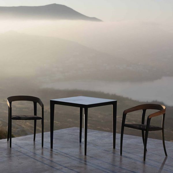 Image of Royal Botania Jive & U-nite outdoor dining set on terrace with cloudy coast in background