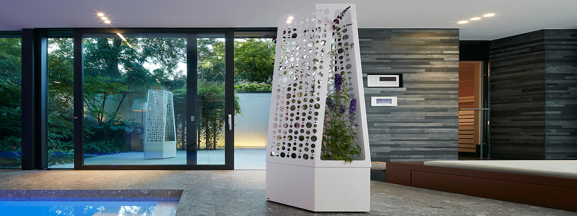 Image of Flora Air planter with trellis on wheels shown on indoor poolside, with another Air planter shown outside