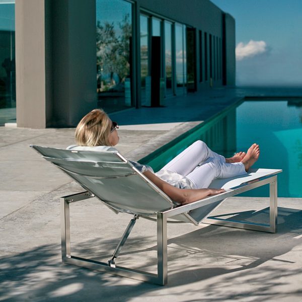 Image of woman reclining in Ninix stainless steel lounge bed by Royal Botania outdoor furniture
