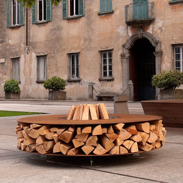 Image of AK47 Zero circular fire pit loaded with firewood outside Italian palazzo.