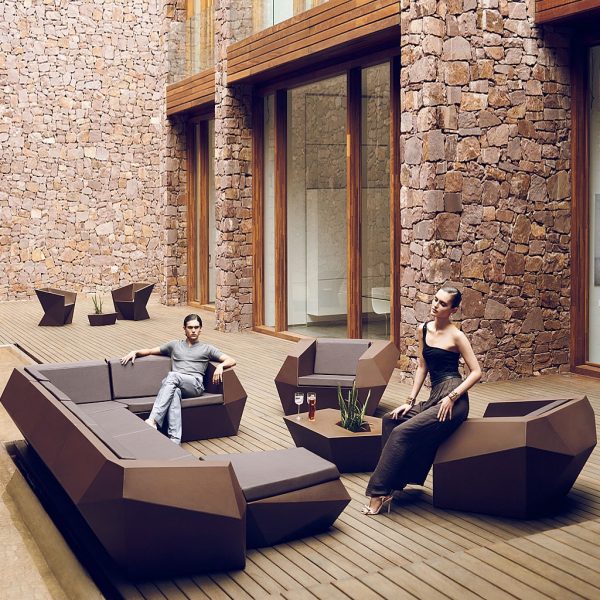 Image of couple relaxing on Vondom Faz brown luxury garden sofa in peaceful courtyard