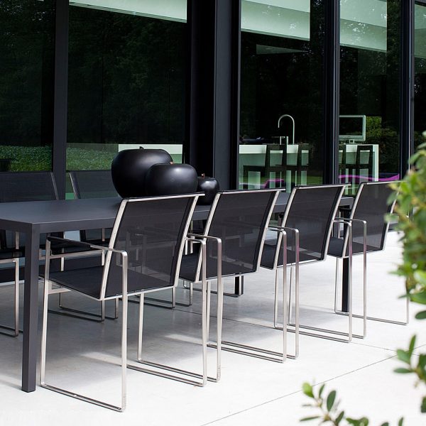 Image of Nimio large black garden table and Sillon stainless steel dining chairs by FueraDentro