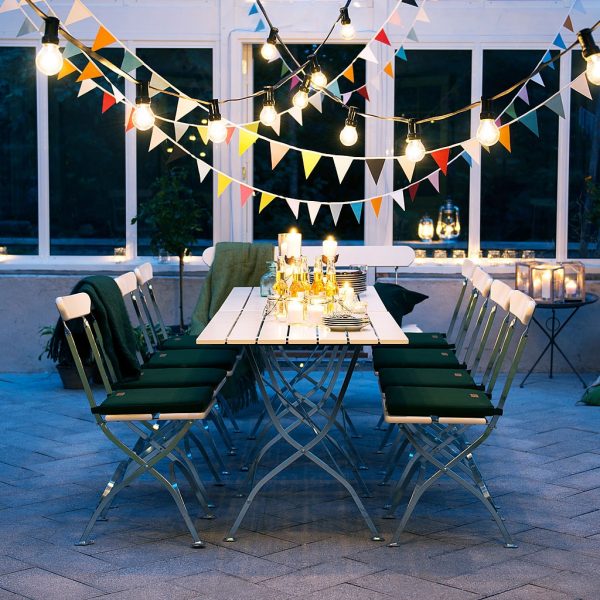 Brewery foldaway garden dining furniture in White lacquered oak beneath colourful fairy lights on terrace