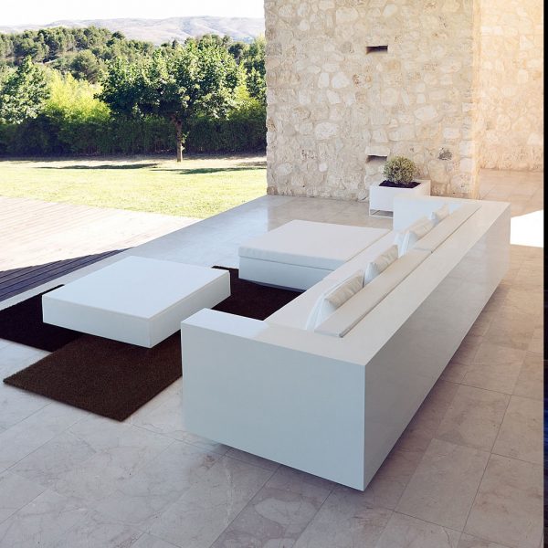 Image of lacquered white Vela outdoor sofa in shady spot on a terrace