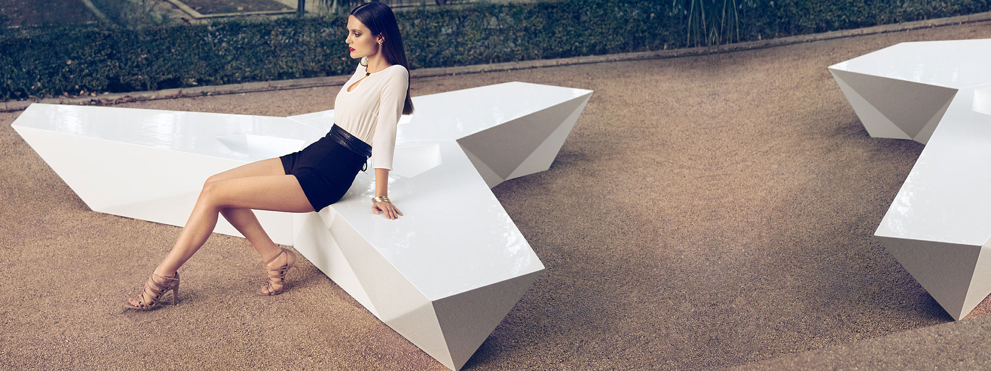 Image of woman sat on configuration of Vondom Faz modular bench in white lacquered finish