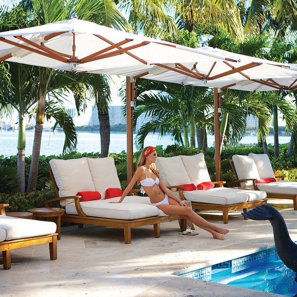 Image of woman sat on sun lounger in shade beneath Tuuci Ocean Master Max cantilever parasol with Aluma-Teak mast and ribs and white canopy