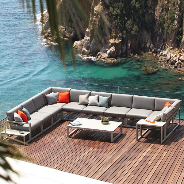 Large Ninix corner sofa on decking over sea from Encompassco