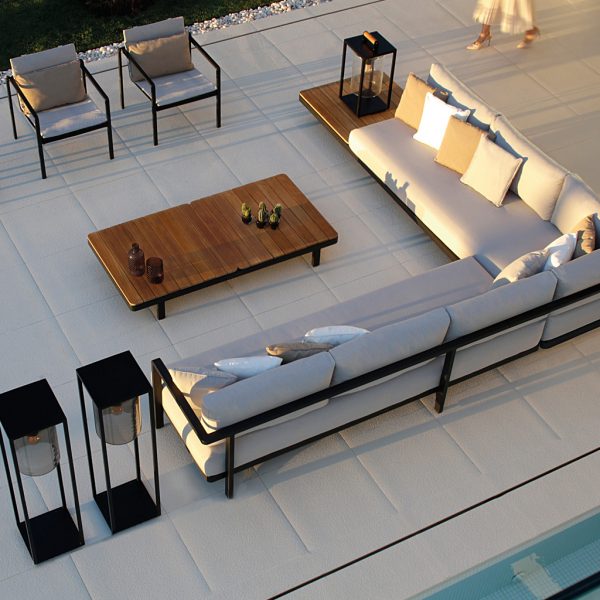Birdseye view of Alura outdoor corner sofa in black with teak-top low tables and Dome garden lamps