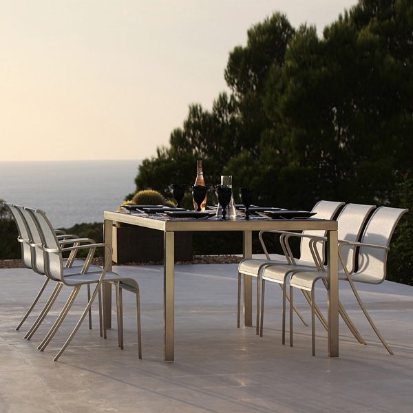 Image of QT55 chairs & Taboela dining table by Royal Botania on terrace with fir trees and sea in background