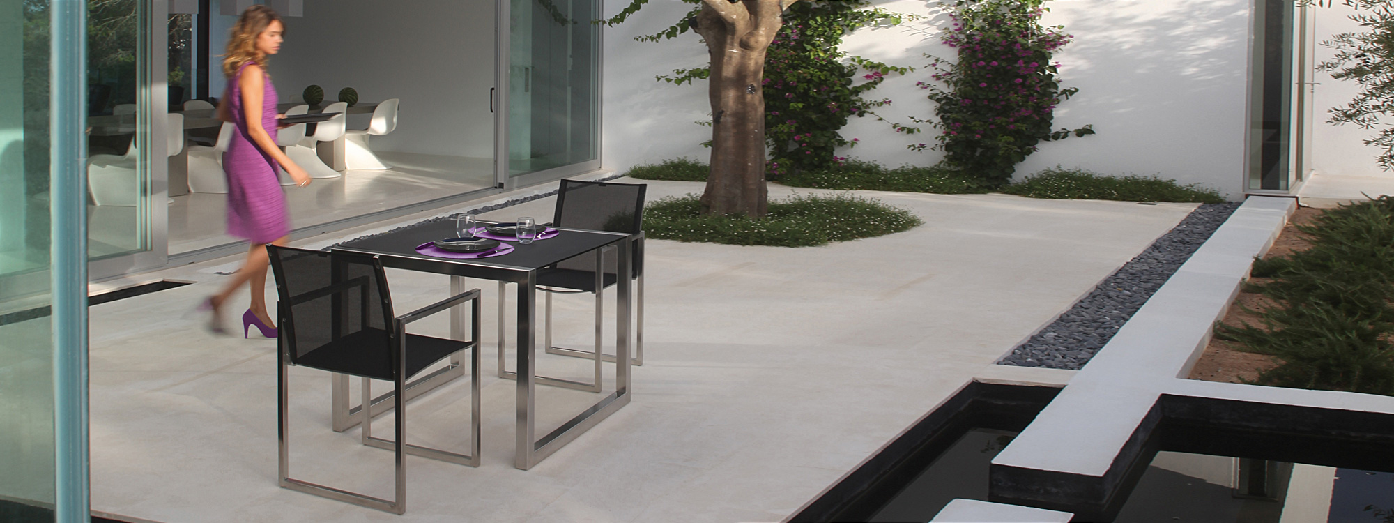 Image of square Ninix dining table and couple of Ninix dining chairs by Royal Botania in sleek courtyard