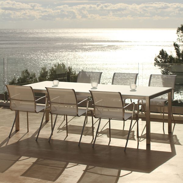 Image of white Taboela garden table & QT55 chairs by Royal Botania on terrace at sunset