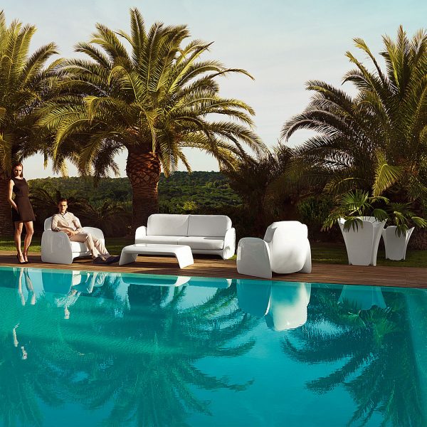 Image of Vondom Pezzettina modern garden lounge furniture on decked poolside, with palm trees and blue sky in the background