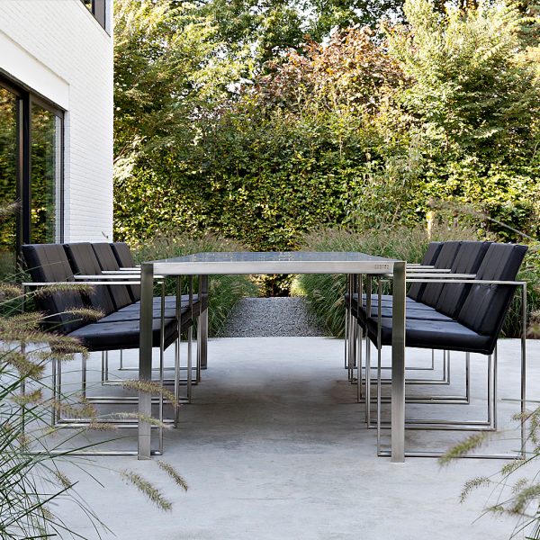 Image looking down the length of Nimio contemporary garden table with Butaque modern garden chairs either side