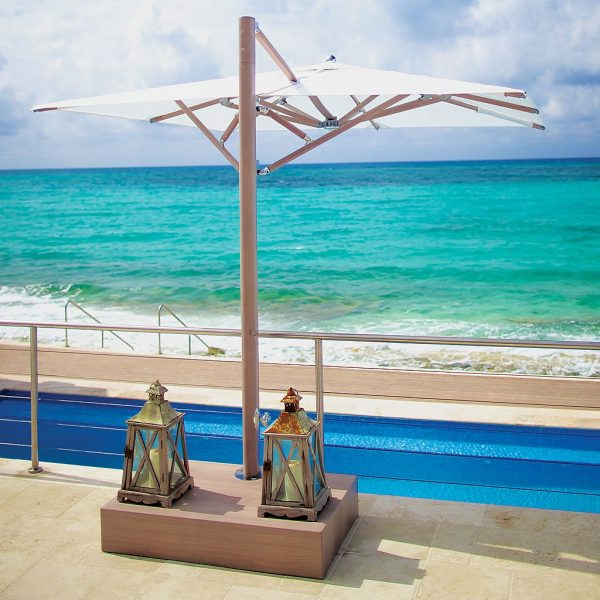 Image of Tuuci Ocean Master Max cantilever parasol with Aluma-Teak mast and ribs and white canopy, with Half Aluma Crete base with lanterns on top