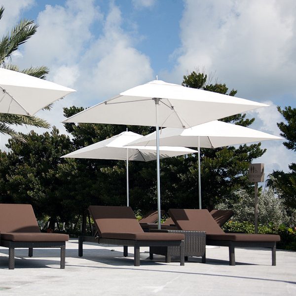 Image of hotel poolside with white Ocean Master center mast parasols with polished titanium mast and ribs, with brown sun loungers beneath