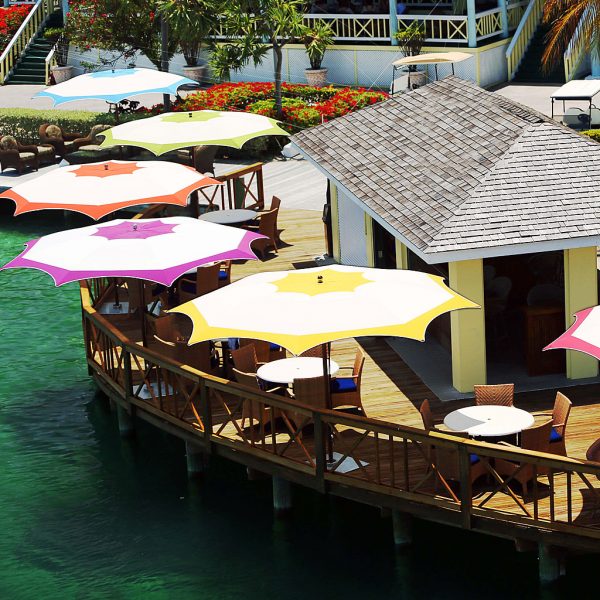 Image of aerial view of Ocean Master Max octagonal mast parasols with multi-colored canopies, installed on raised deck in marina