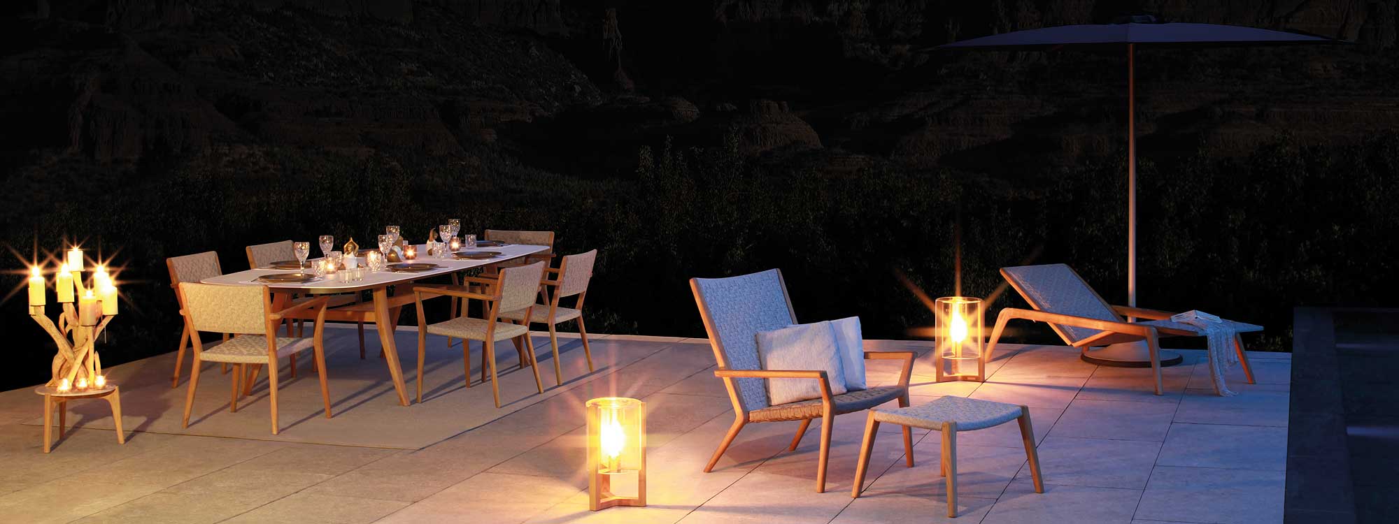 Nighttime shot of Vita modern garden lounge chair is a luxury outdoor easy chair & foot stool in high quality materials by Royal Britannia contemporary teak garden furniture